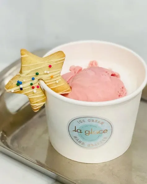 FRAMBOISE BLANCHE (takeout only). Available January 16 - February 14, 2021. White hot chocolate poured over a scoop of raspberry white chocolate ganache ice cream. Served with a sablé star cookie. 