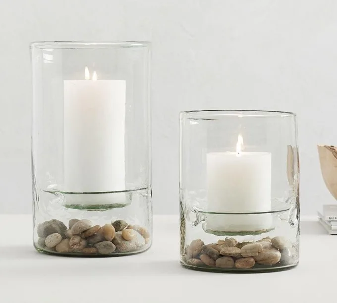 Clear glass vases with candles and decorative pebbles