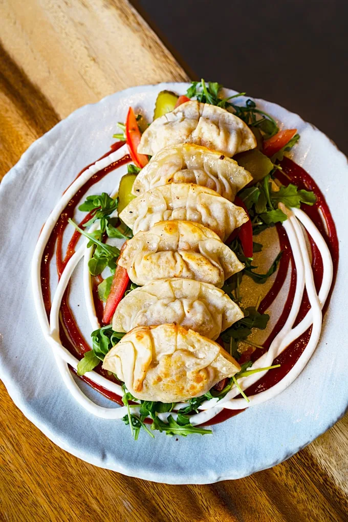 plant-based Beyond meat potstickers with vegan cheese, tomato &
arugula salad, vegan aioli and a hickory BBQ sauce