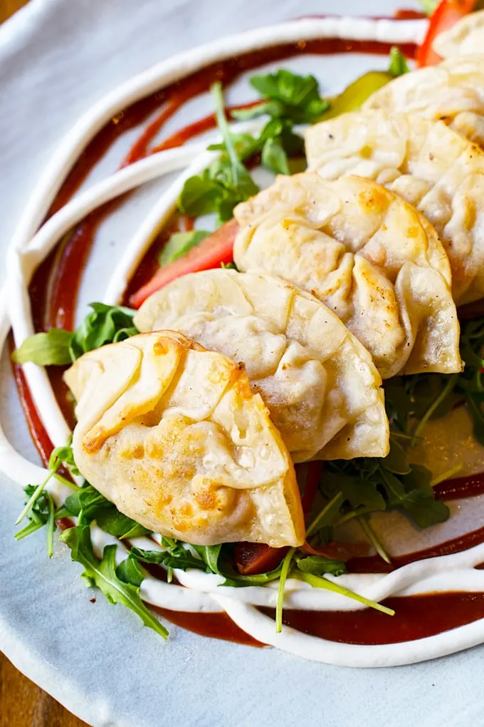 plant-based Beyond meat potstickers with vegan cheese, tomato &
arugula salad, vegan aioli and a hickory BBQ sauce