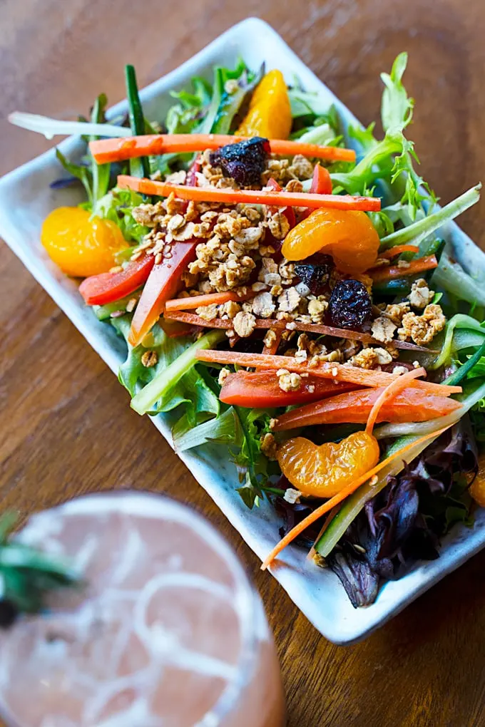 organic green salad with lemon balsamic vinaigrette, dried cranberries and crunchy and tasty granola topping