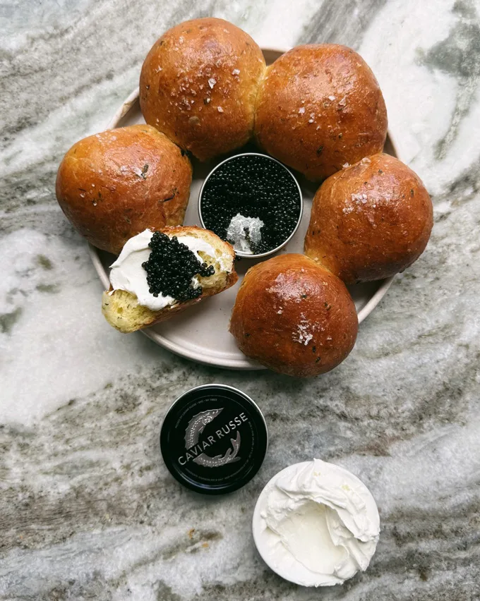 A luxurious herbed brioche bun infused with chives, ramps, dill and sea salt and served with lemon labneh featuring a touch of zest for a unique presentation. Caviar Russe’s classic Osetra caviar completes the ensemble.