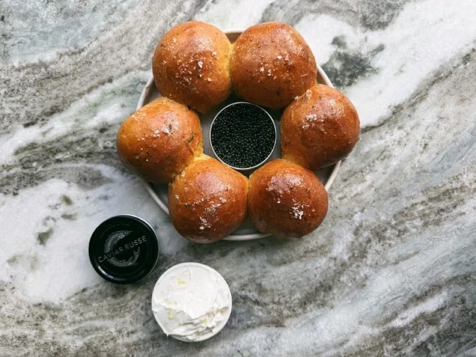 A luxurious herbed brioche bun infused with chives, ramps, dill and sea salt and served with lemon labneh featuring a touch of zest for a unique presentation. Caviar Russe’s classic Osetra caviar completes the ensemble.