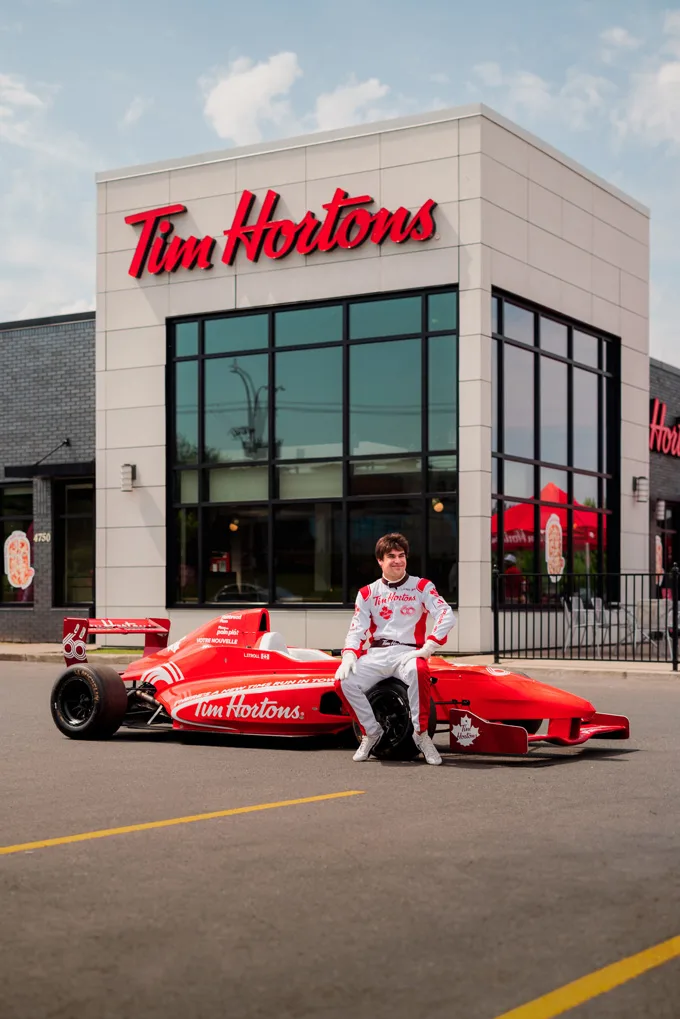 Canadian Formula One driver Lance Stroll goes on a unique Tims Run with a Tim Hortons-branded race car at a hometown Tims drive-thru in Montreal