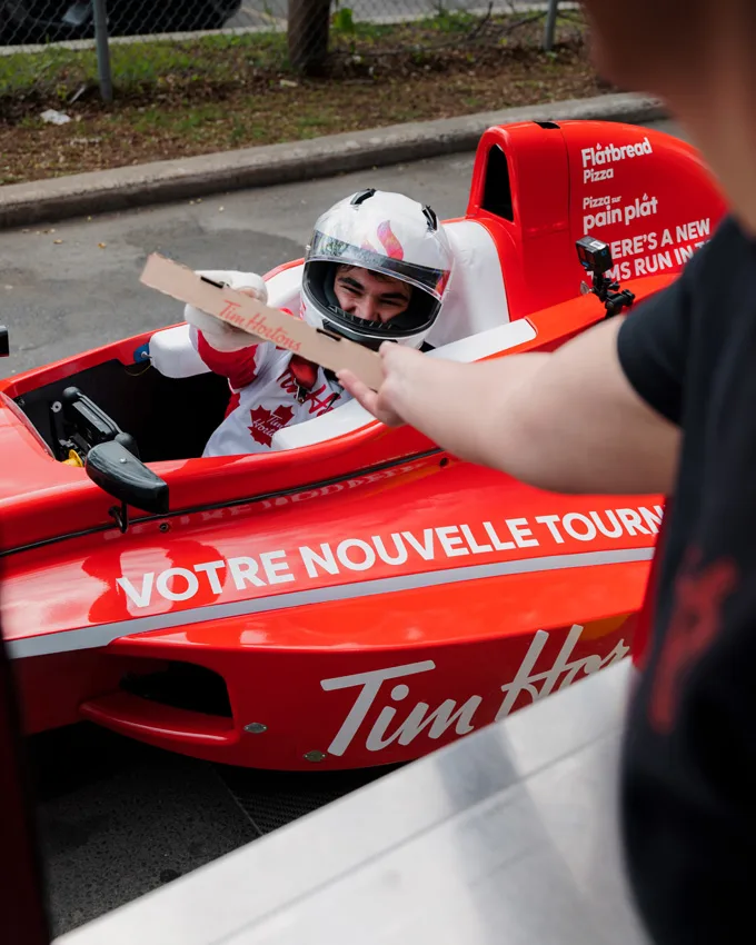 Canadian Formula One driver Lance Stroll goes on a unique Tims Run with a Tim Hortons-branded race car at a hometown Tims drive-thru in Montreal